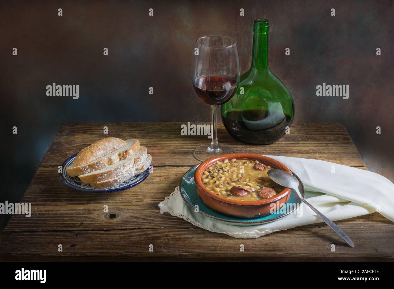 Ancora la vita di fagioli bianchi con il vino e il pane su un vecchio sfondo di legno scuro, Fotografia di cibo Foto Stock