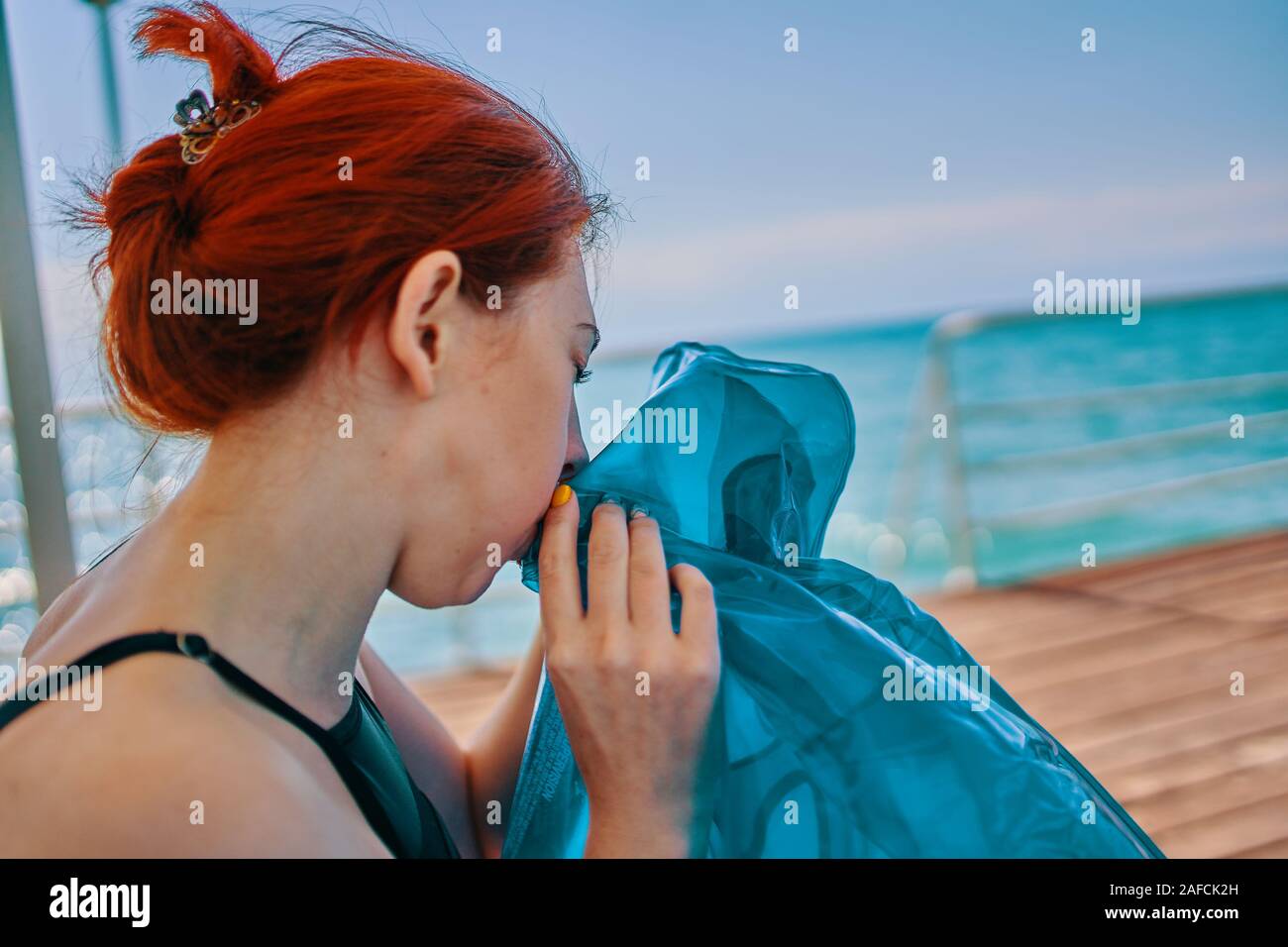 Donna che mantiene l'aria gonfiabile materasso. La donna si gonfia a  ciambella per il nuoto Foto stock - Alamy
