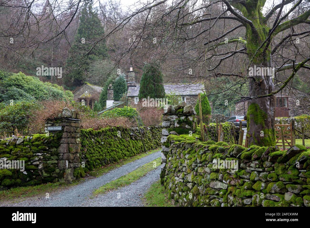 Villaggio di Grasmere e un muro di pietra a secco ricoperto di muschio in un giorno d'inverno, Lake District, Cumbria, Inghilterra. Foto Stock