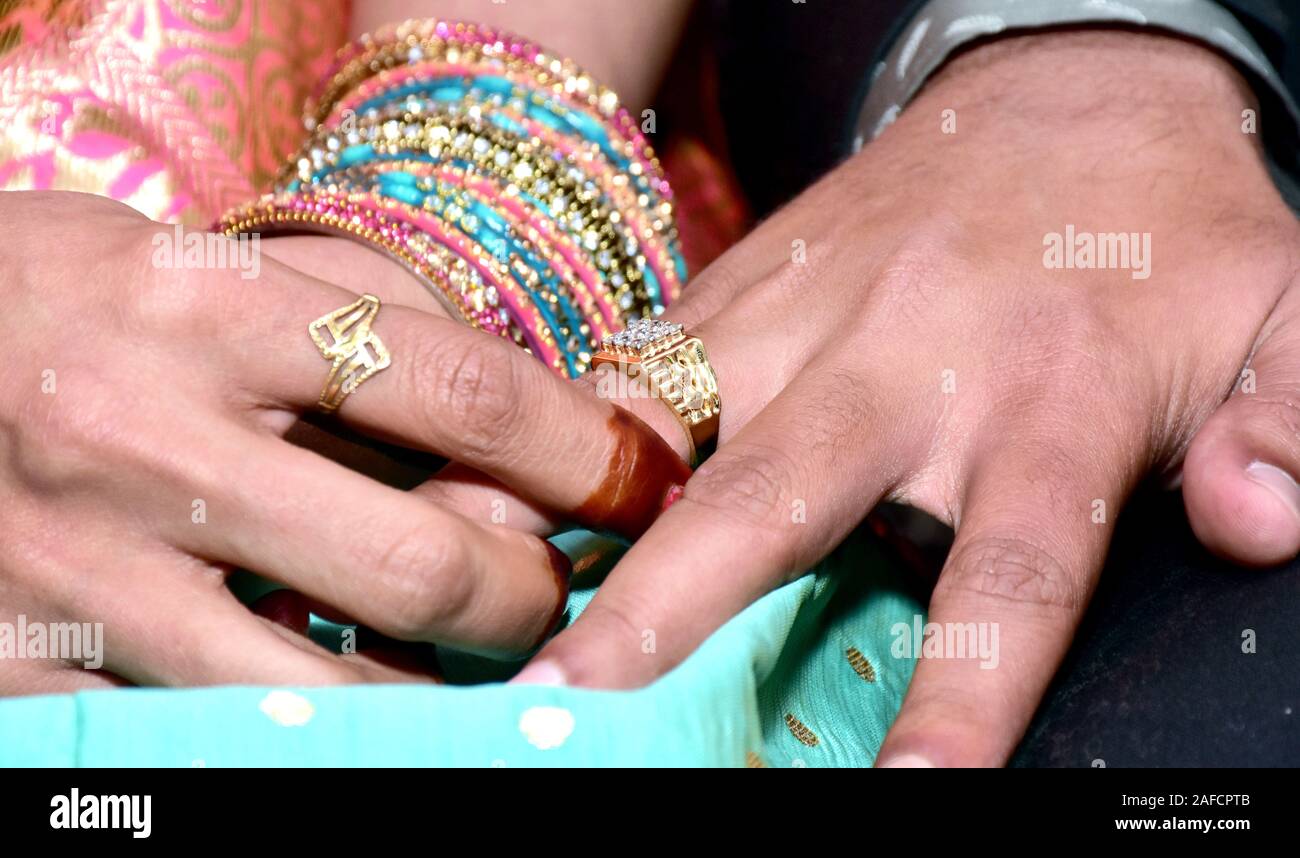 Sposa indiana di mettere un anello di nozze su groom del dito Foto Stock