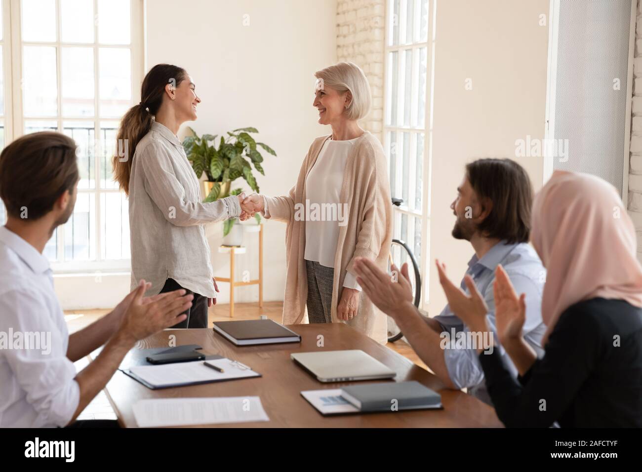 Il boss sorridenti lodando collaboratore alla riunione di affari. Foto Stock