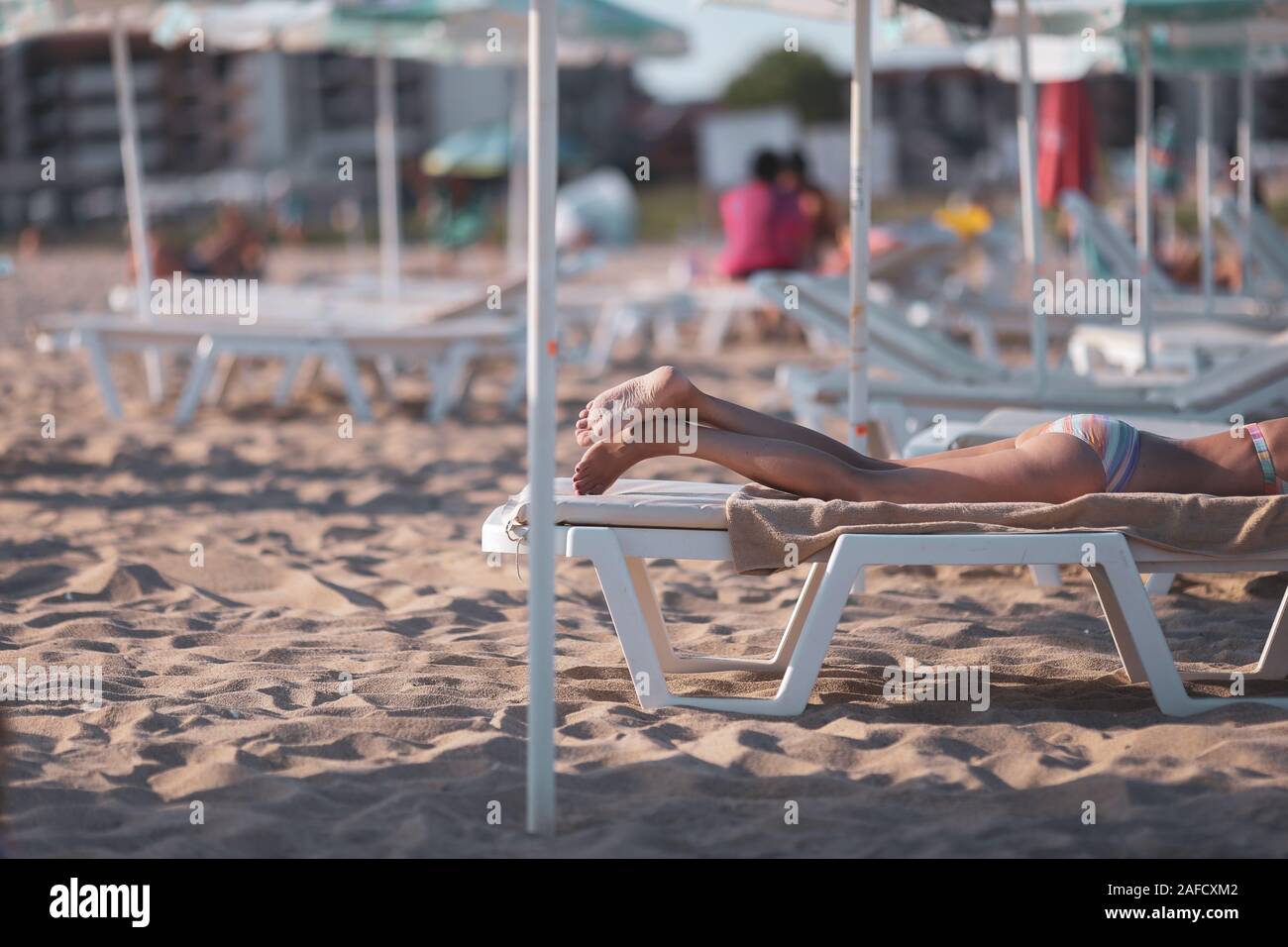 Le persone anziane godendo di prendere il sole sulla spiaggia durante le loro vacanze estive Foto Stock