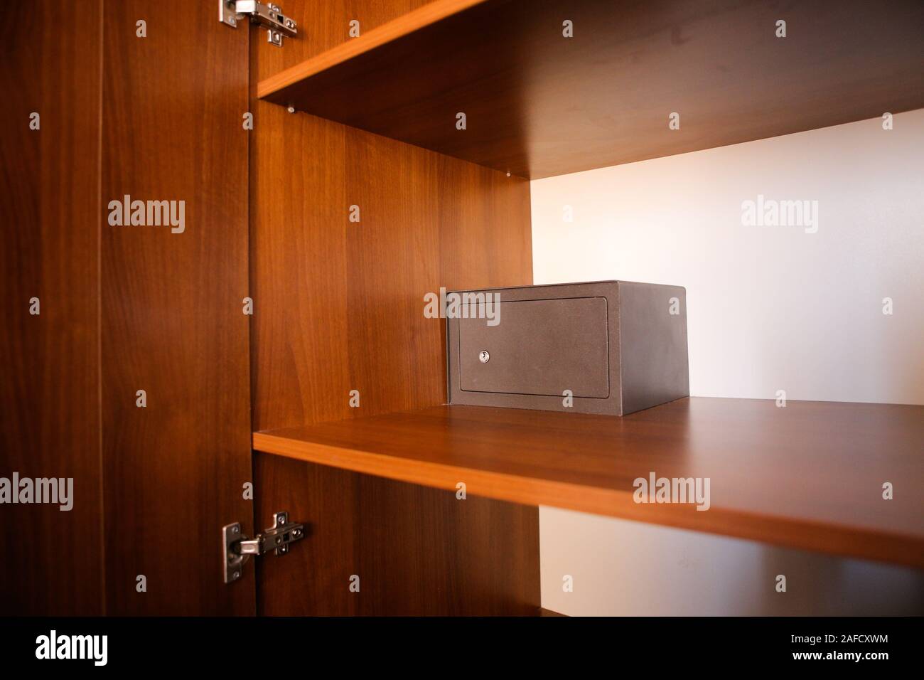 Cassaforte in metallo all'interno di un vuoto di armadio in legno in una camera di hotel Foto Stock