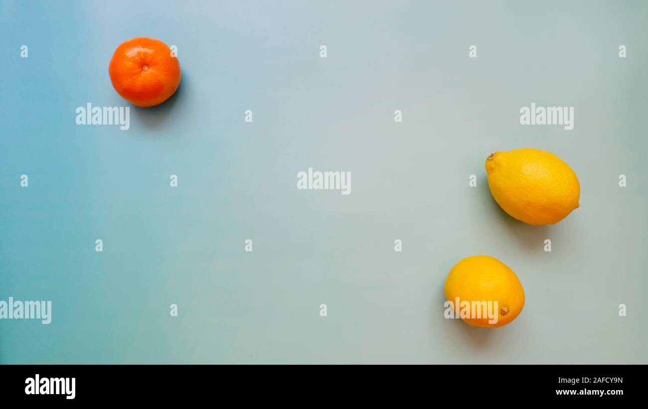 Vista dall'alto di un arancio mandarino e due limoni, con copia spazio in mezzo. Foto Stock