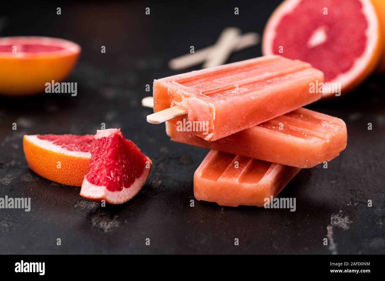 Vintage lastra di ardesia con alcuni freschi Pompelmi Popsicles (messa a fuoco selettiva; close-up shot) Foto Stock