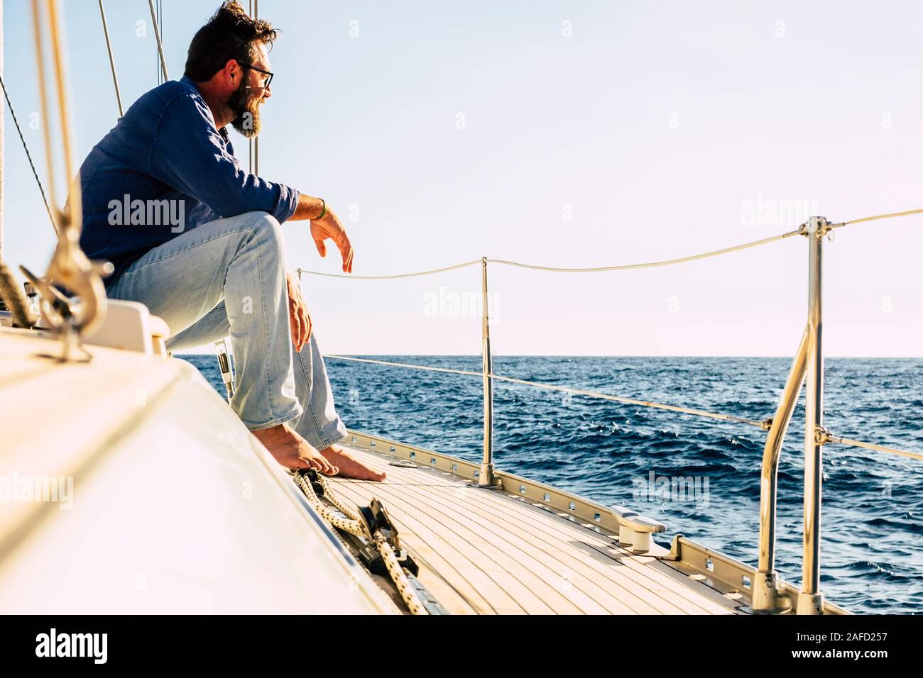 Concetto di persone in viaggio con uomo caucasico sedersi su una imbarcazione a vela guardando l'oceano blu e godendo l'escursione o un lusso lifetyle - outdoor Foto Stock