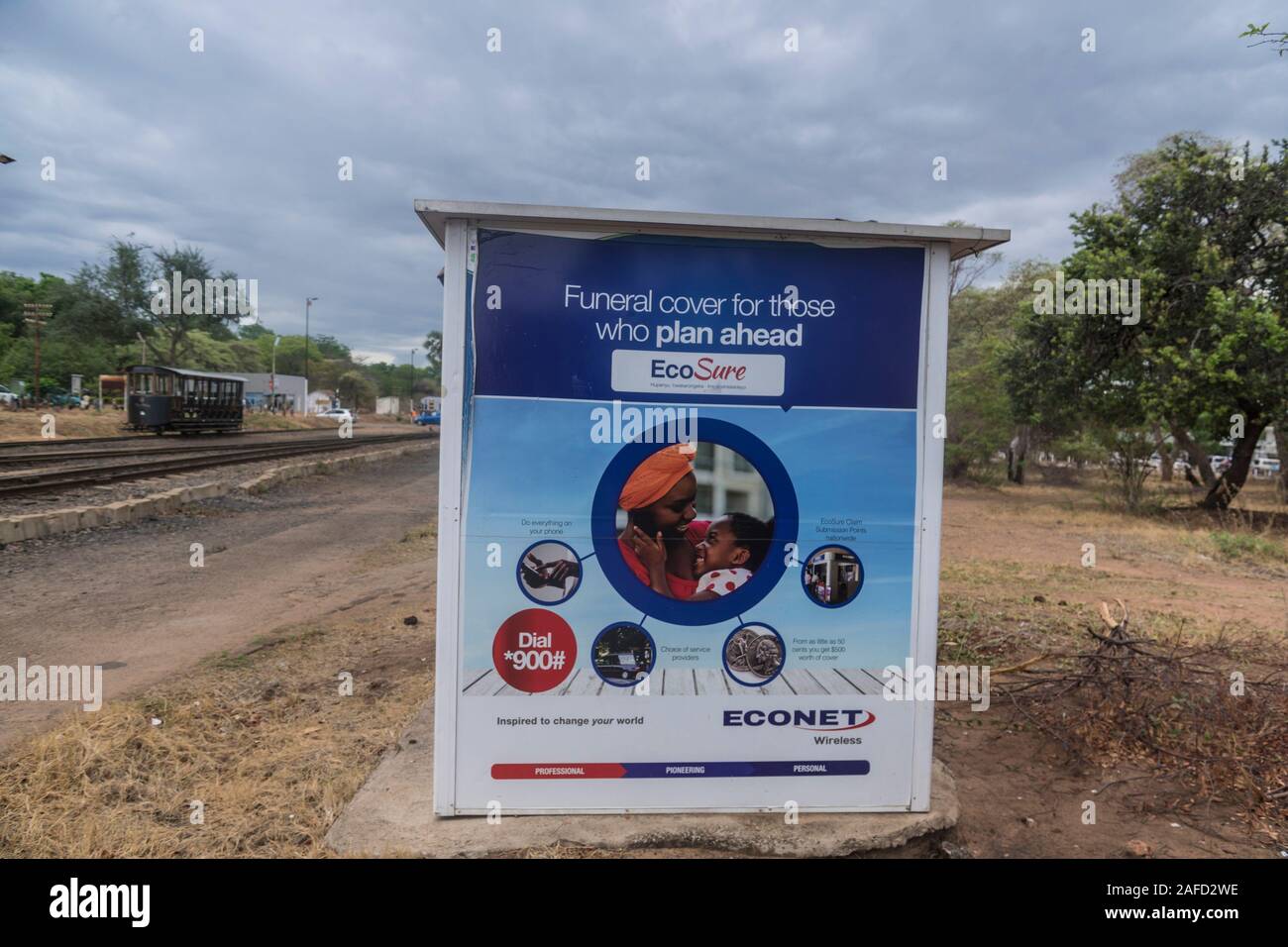 Cascate Victoria, Zimbabwe. Un annuncio per l'assicurazione funeraria in Zimbabwe. L'assicurazione 'Ecosure' è offerta da Econet, una società locale che detiene la più grande rete wireless in Zimbabwe, e anche un servizio di pagamento telefonico, Ecofin. Nel giugno 2020 il governo dello Zimbabwe ha dichiarato di voler chiudere Ecofin, sostenendo che l'azienda ha utilizzato un rapporto di cambio non ufficiale e ha quindi contribuito all'inflazione nel paese. Questo passo avrà gravi risultati, in quanto Ecofin sostituisce il conto bancario di molte delle popolazioni povere del paese. Foto Stock