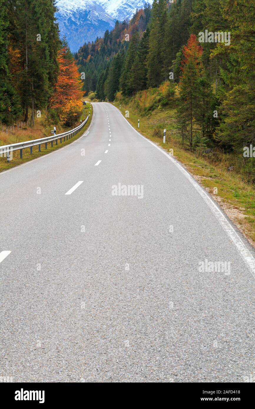 Avvolgimento su strada forestale in splendidi colori autunnali in Baviera Alpi, Parco Nazionale di Berchtesgaden in Germania Foto Stock