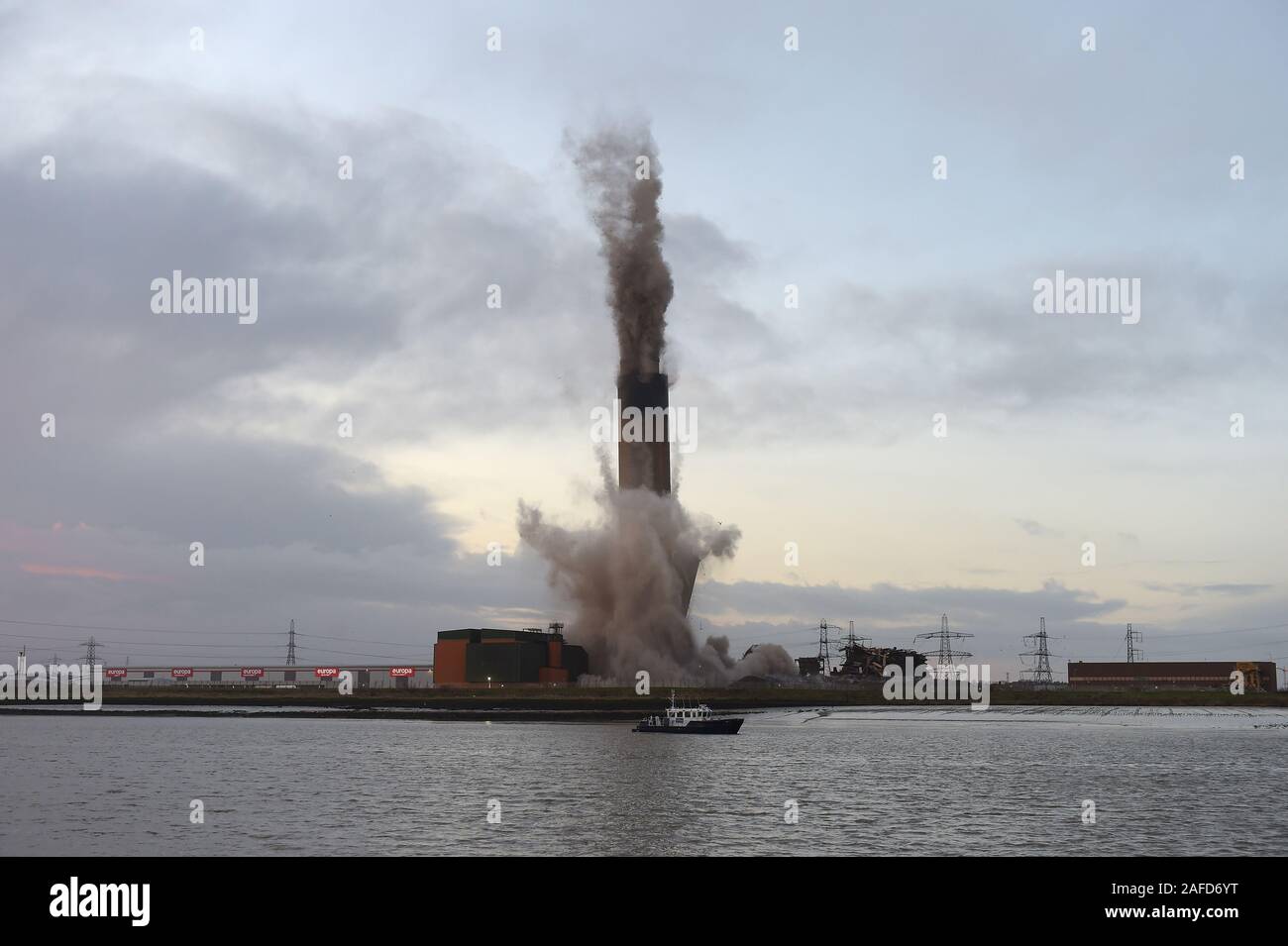 Dartford, Kent, Regno Unito. Il 15 dicembre 2019. La demolizione dei 215 metri di camino al Littlebrook Power Station è il prossimo passo per lo smantellamento degli impianti chiusi nel 2015 e ha aperto per la prima volta come una centrale a carbone stazione in 1939 ed è stato un sistema di navigazione per la Luftwaffe durante il WW2. Il blast condotta da Kent base impresa di demolizione marrone e Mason ha causato una temporanea chiusura del vicino QE2 ponte che attraversa il fiume Tamigi da Essex di Kent. Il camino si fermò due volte alto come il Big Ben e è stato il secondo più grande nel regno Unito. Credito: Martin Dalton/Alamy Live News Foto Stock