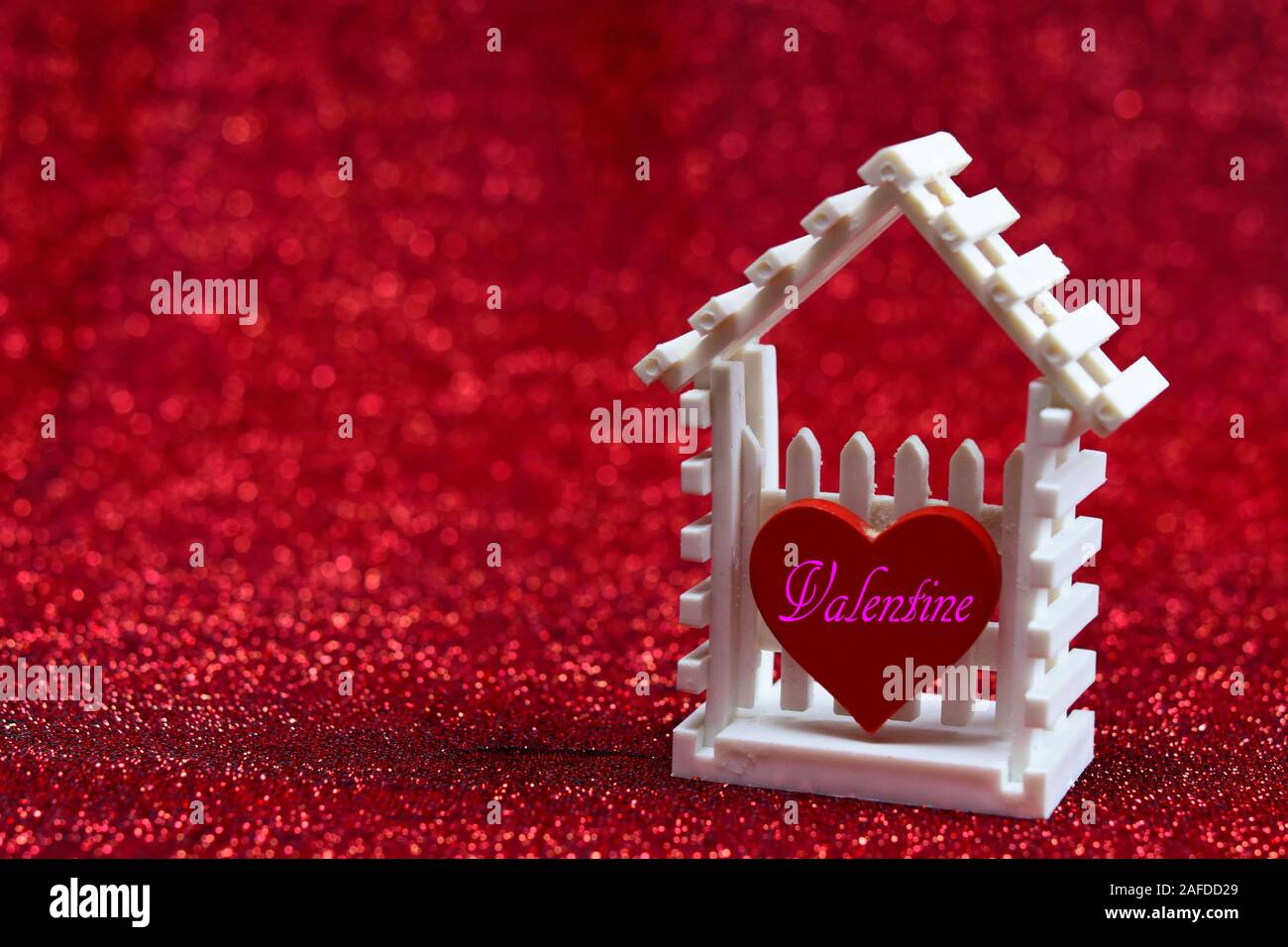 Little white house e cuore rosso scritto con parole " Buon San Valentino ' su sfondo rosso per il design pattern o il vostro concetto di San Valentino. Foto Stock