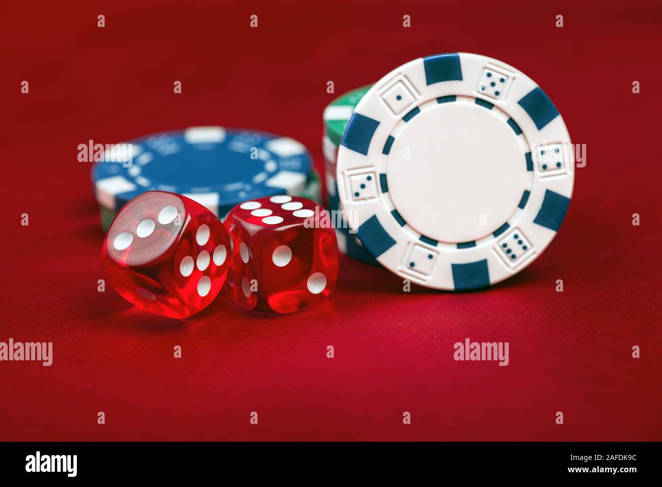 Dadi e casino chips su sfondo rosso. Il concetto di gioco d'azzardo Foto Stock