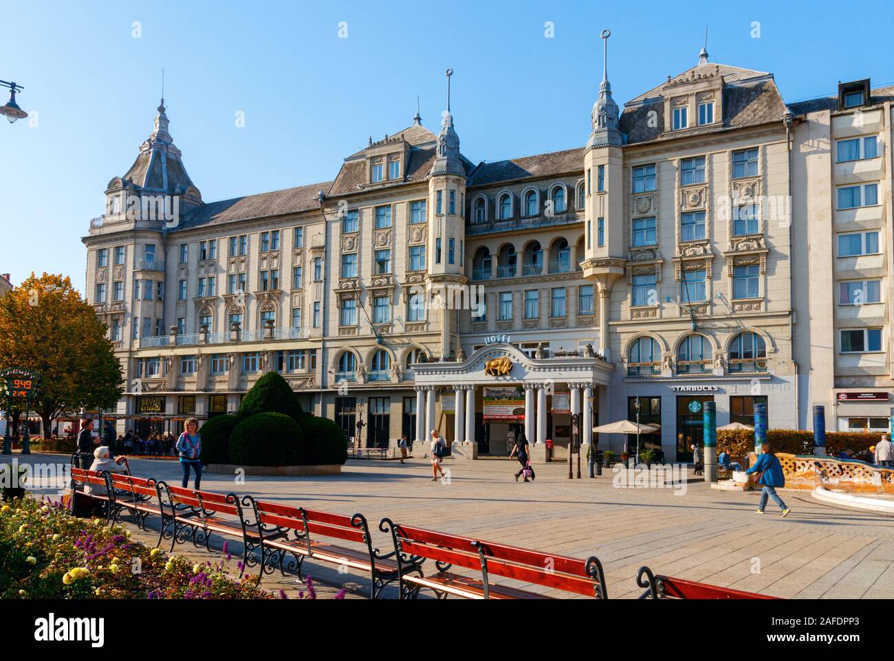 Kossuth Square con la facciata neoclassica del Grand Hotel Aranybika sotto un cielo blu. Debrecen, Ungheria. Foto Stock