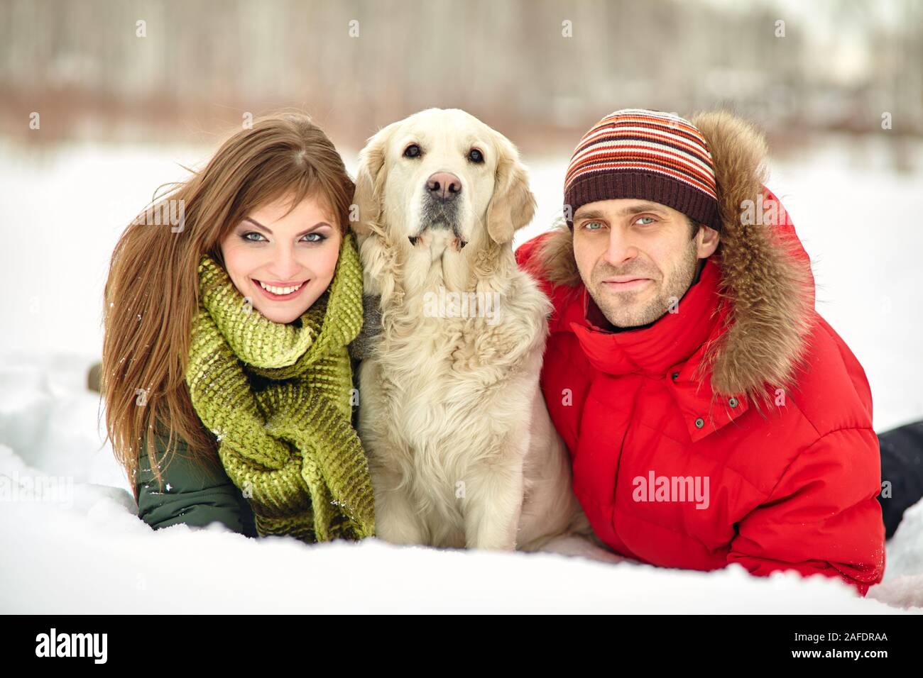 giovane coppia con un cane in una passeggiata invernale, uomo e donna con labrador all'aperto. Foto Stock