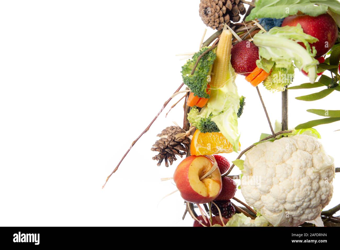 Frutta e verdura a tema Natale corona di fiori ornamentali su uno sfondo bianco con spazio di copia Foto Stock