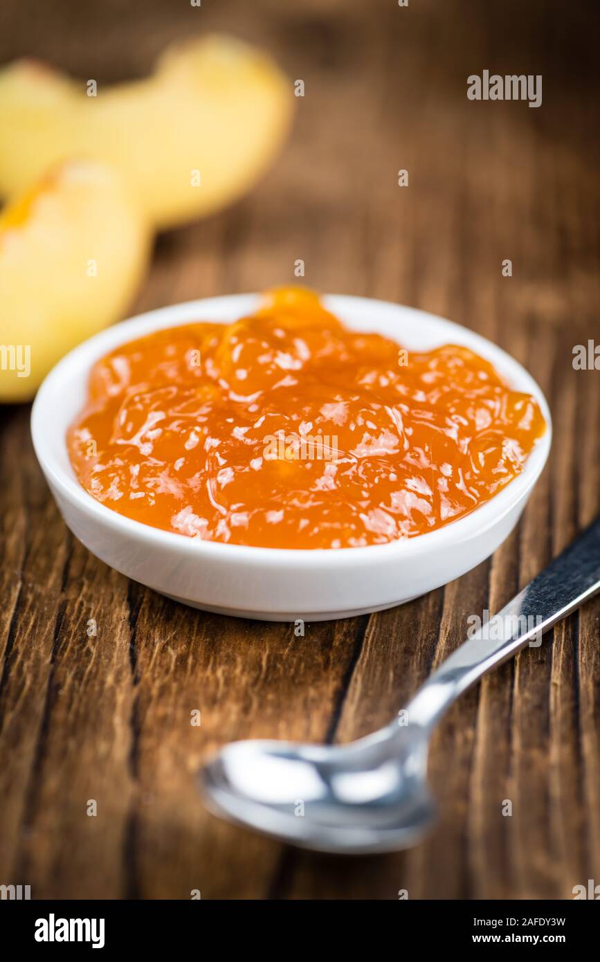 Porzione di confettura di pesche (close-up shot) su un vecchio tavolo in legno Foto Stock