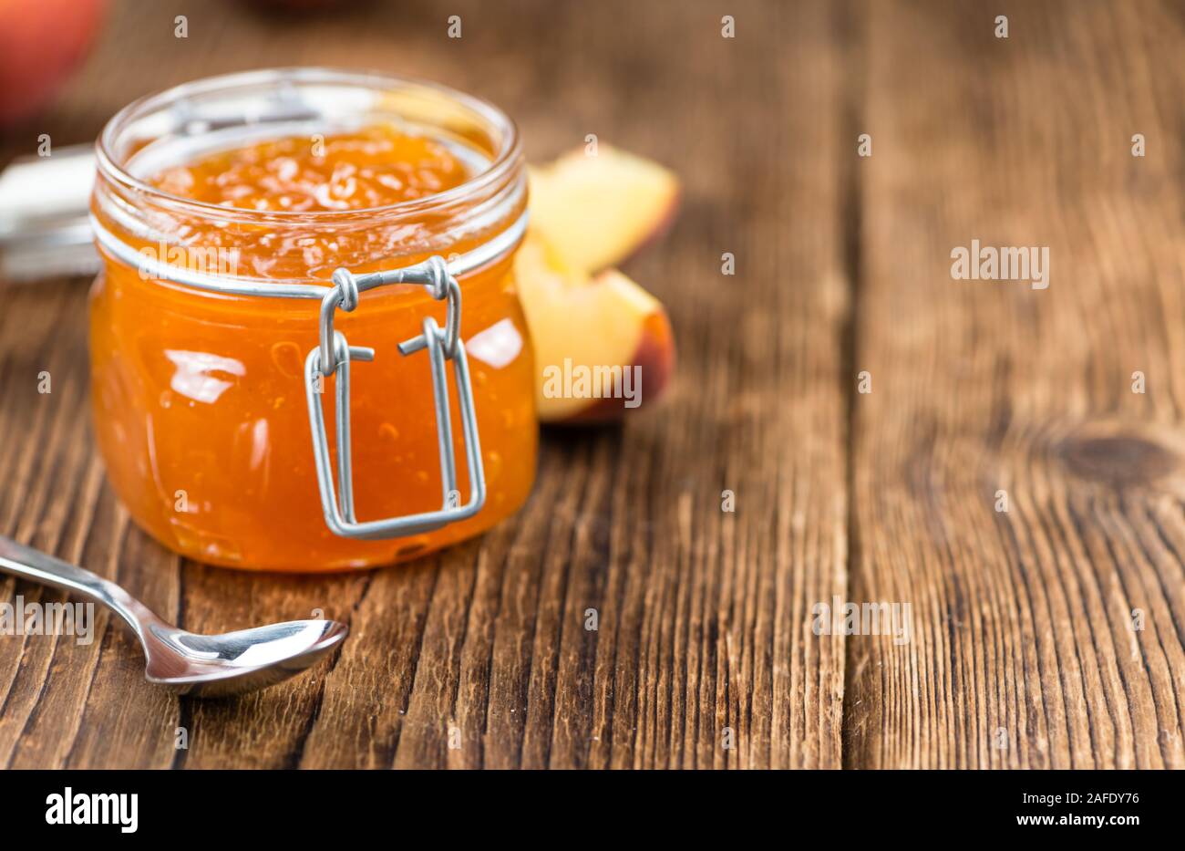 Porzione di confettura di pesche (close-up shot) su un vecchio tavolo in legno Foto Stock