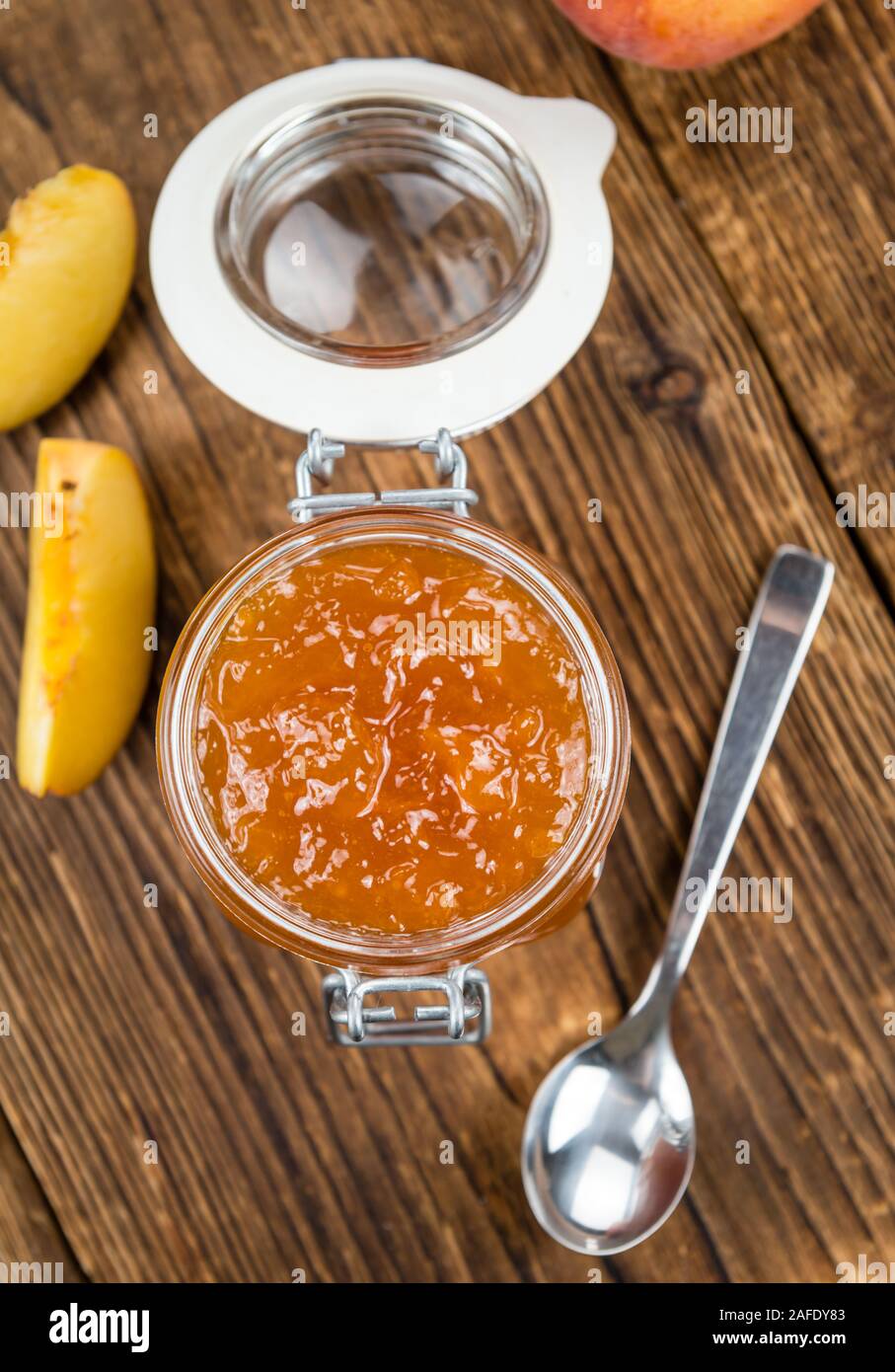 Tavolo in legno con confettura di pesche (messa a fuoco selettiva; close-up shot) Foto Stock