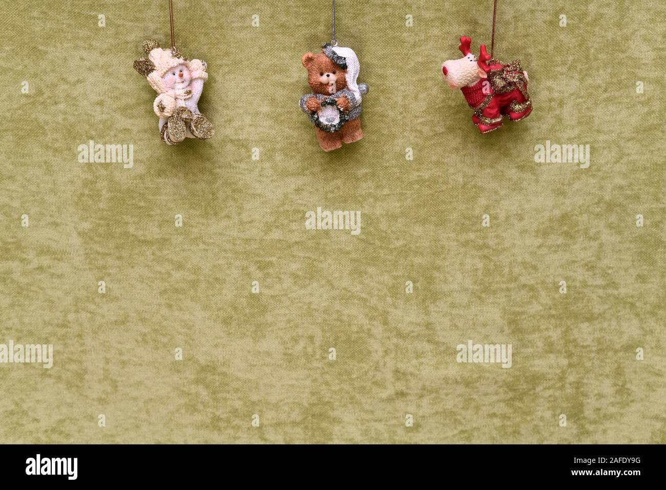 Giocattoli di natale, snowman, Teddy bear e cervi, sospeso in alto, su un verde sullo sfondo di peluche. Foto Stock