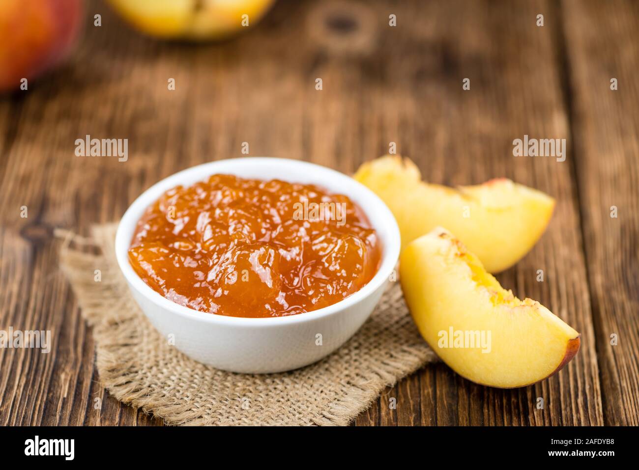 Porzione di confettura di pesche (close-up shot) su un vecchio tavolo in legno Foto Stock