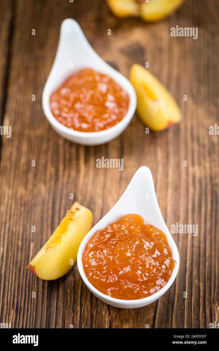 Porzione di confettura di pesche (close-up shot) su un vecchio tavolo in legno Foto Stock