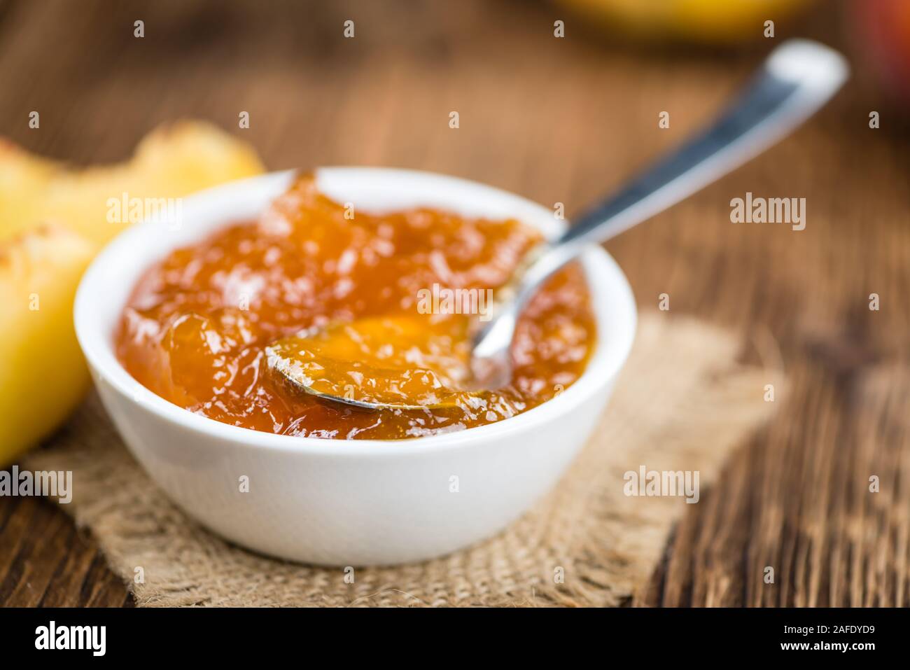 Tavolo in legno con confettura di pesche (messa a fuoco selettiva; close-up shot) Foto Stock