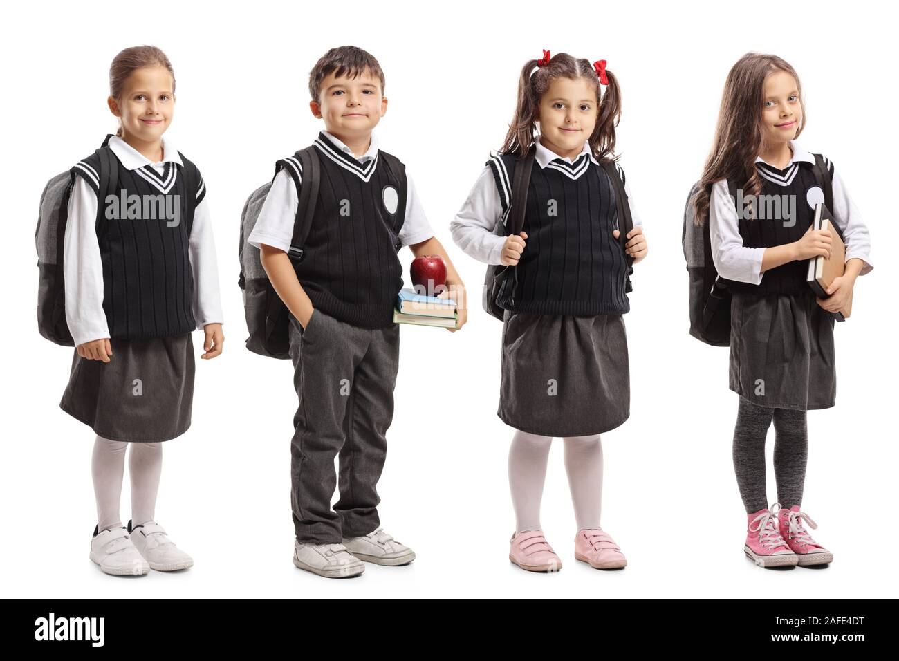 Un gruppo di alunni con zaini che indossa una uniforme scolastica isolati su sfondo bianco Foto Stock
