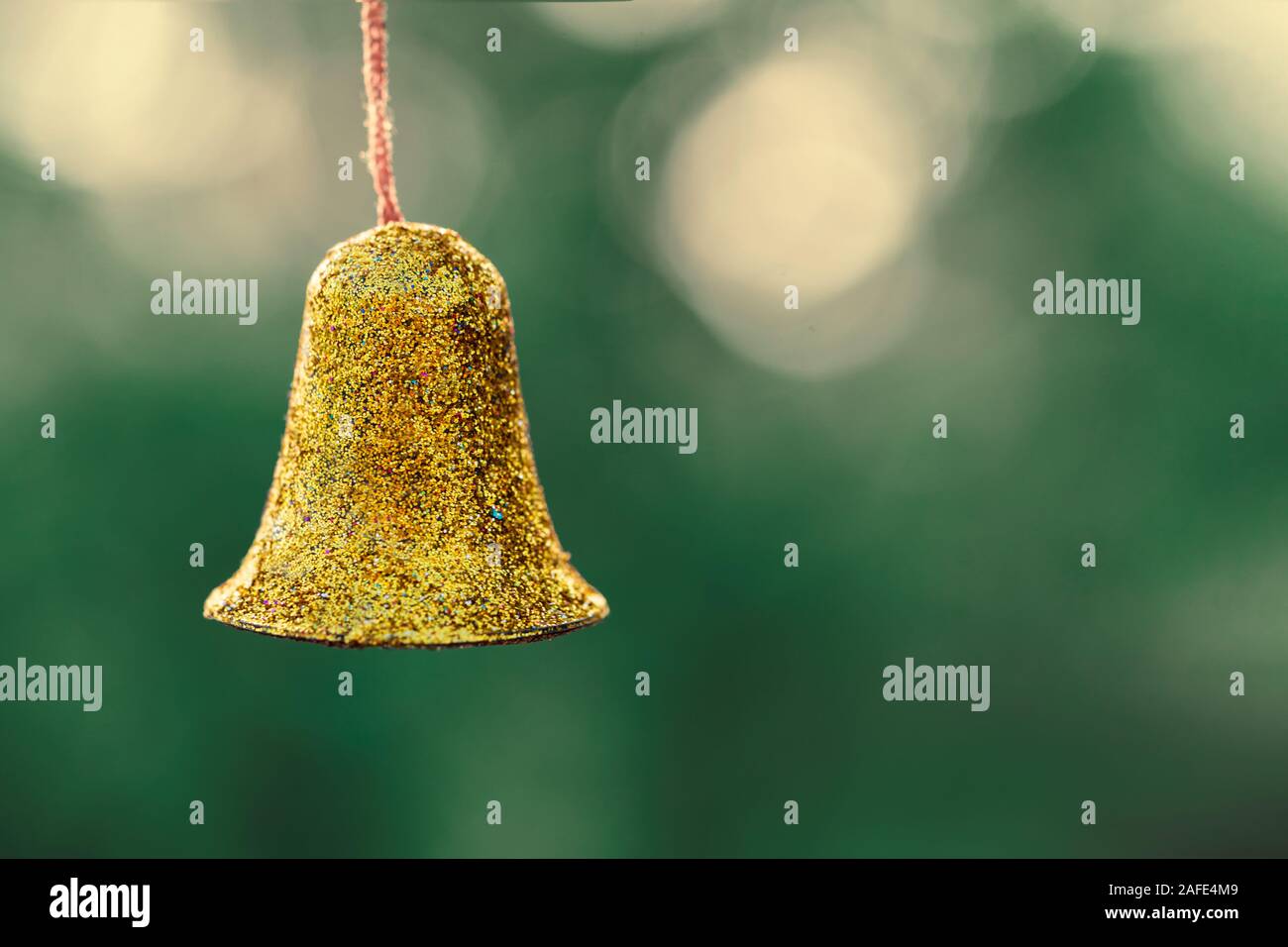 Sfondo di natale di una decorazione a campana d'oro appeso fuori con copia spazio. Concetto di vacanza per biglietto di auguri, cartolina, la tradizione cristiana, cu Foto Stock