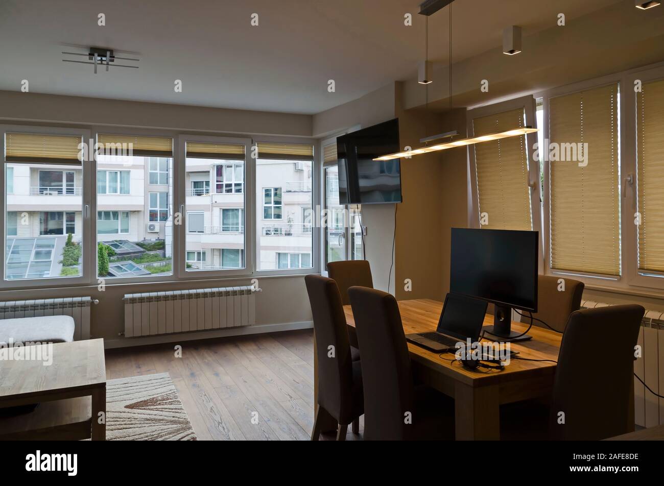 Parte di una struttura ristrutturata di recente e soggiorno con TV, tavolo, sedie, computer laptop, il telefono cellulare e la cuffia, Sofia, Bulgaria, Europa Foto Stock