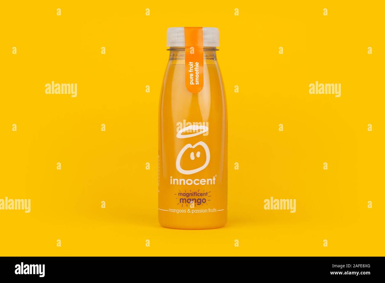 Una bottiglia di Innocenzo magnifico frullato di Mango bere shot su sfondo giallo. Foto Stock