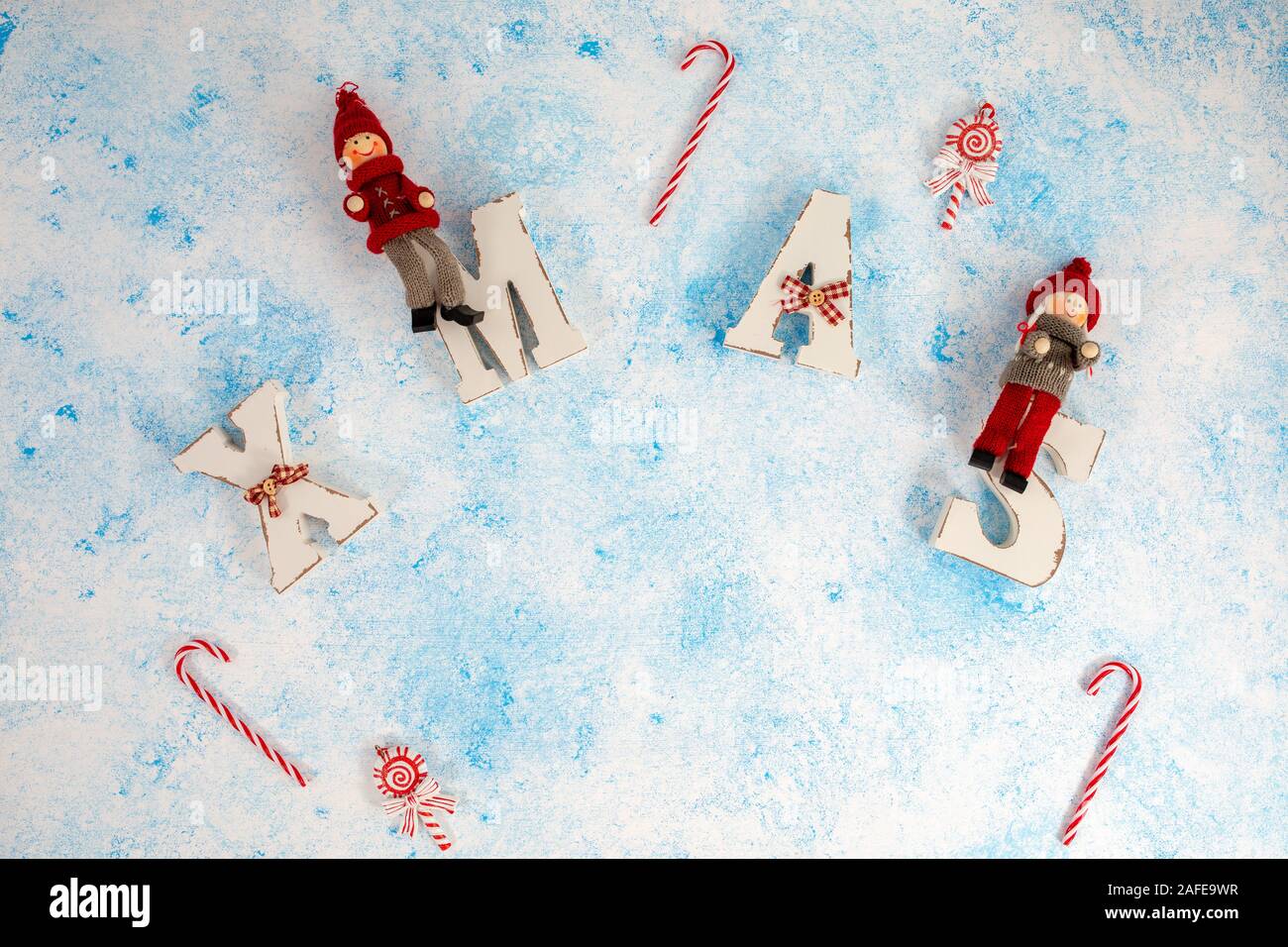 Titolo Xmas con con la caramella bianco in legno sfondo blu. Christmas Festive card, vacanze Foto Stock