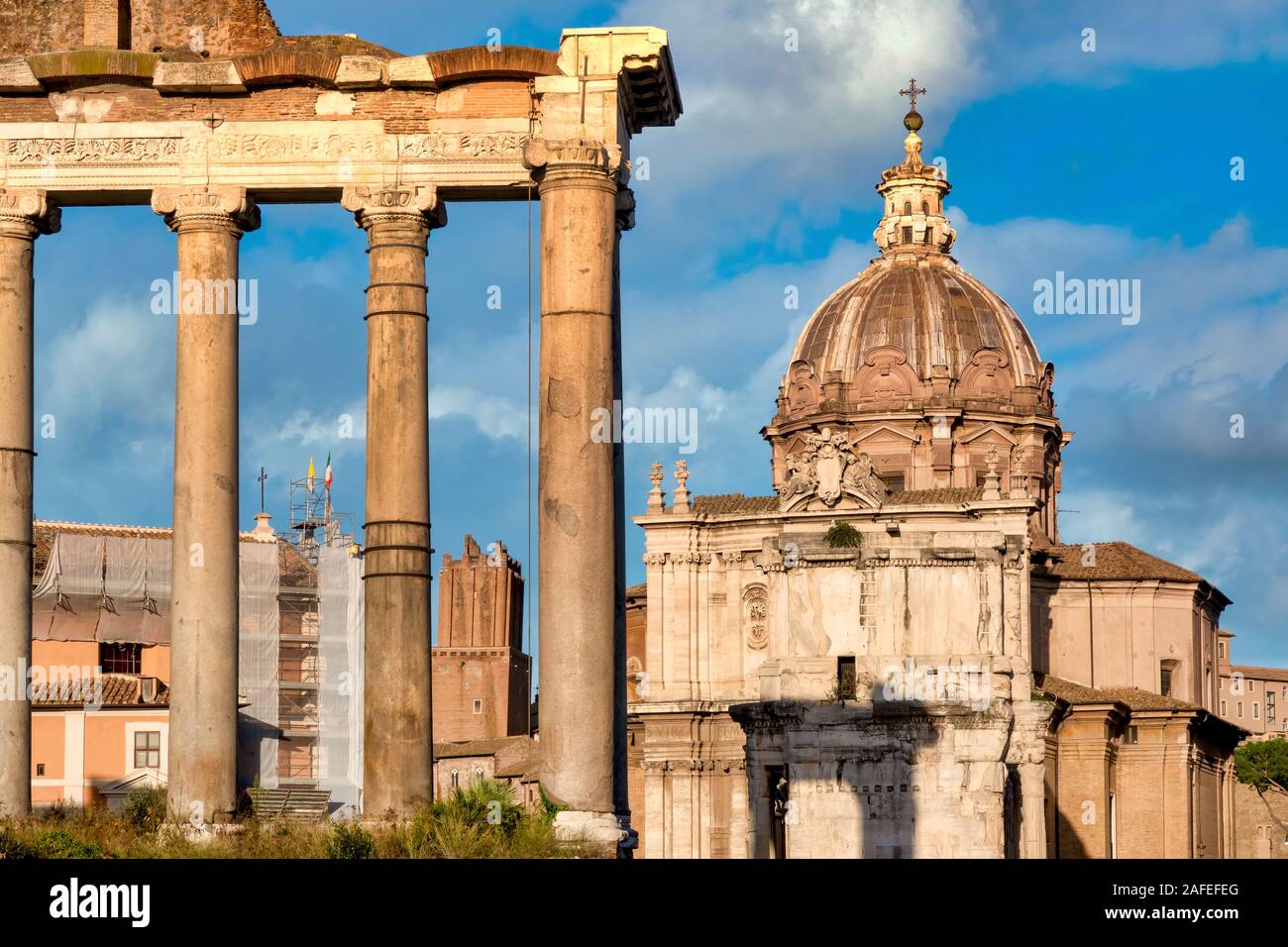 Resti di colonne del tempio di Saturno e la cupola della chiesa dei Santi Luca e Martina, Roma, Italia Foto Stock