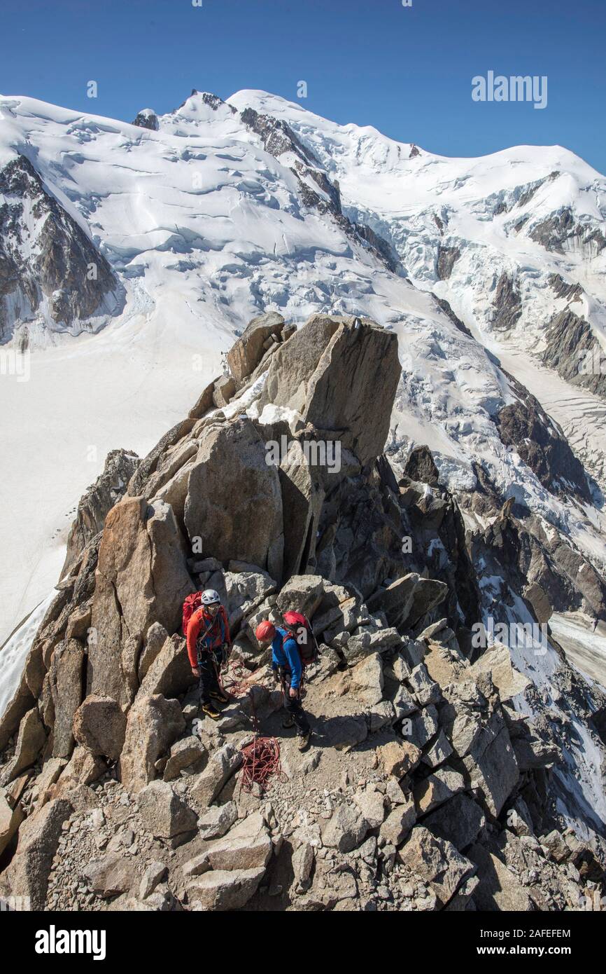 Due alpinisti salire accanto all'Aiguille du Midi piattaforma con Mont Blanc in background. Chamonix. Francia Foto Stock