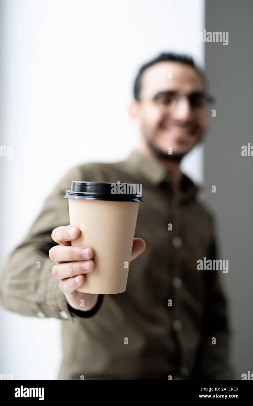 Bicchiere monouso di caffè caldo in mano del giovane imprenditore di successo Foto Stock