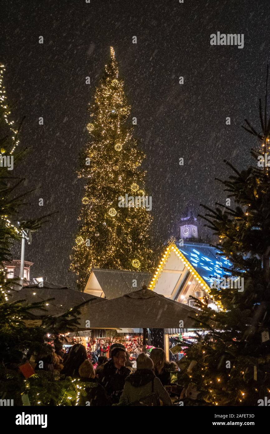 Nevicata sul mercato di Natale Christkindlmarkt sulla piazza principale con Clocktower Uhrturm in Graz, Stiria, Austria Foto Stock