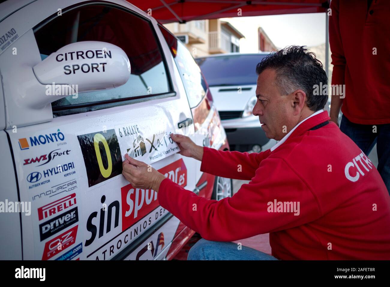 Xixona Sport team stati collocando un adesivo su una Citroën C2 al VI Rallye Bodegas Xaló 2018 (Xaló, Marina Alta, Alicante,Comunidad Valenciana,Spagna) Foto Stock