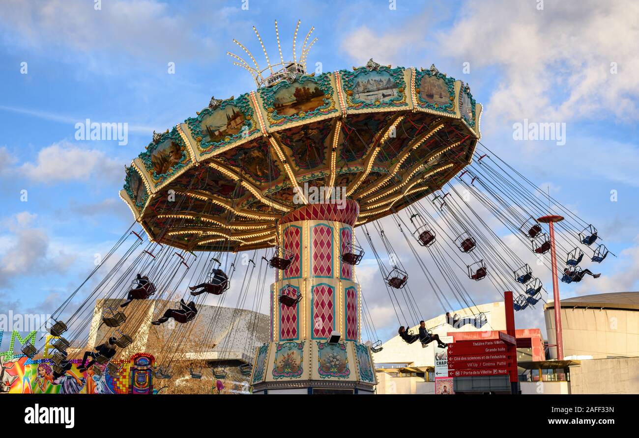 Parigi, Francia - 14 dicembre 2019: bellissima altalena ride giostra in un grande parco di divertimenti trattenuto sulla Place de la Fontaine aux Lions, presso il Parc de la Villette. Foto Stock