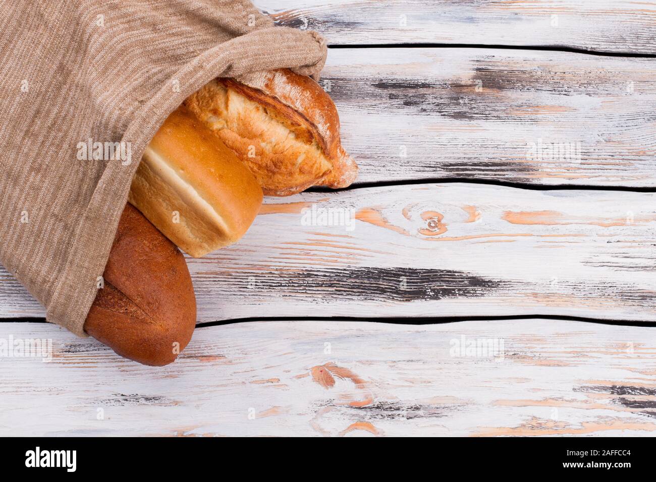 Pane in sacchetto di tela su sfondo di legno. Foto Stock