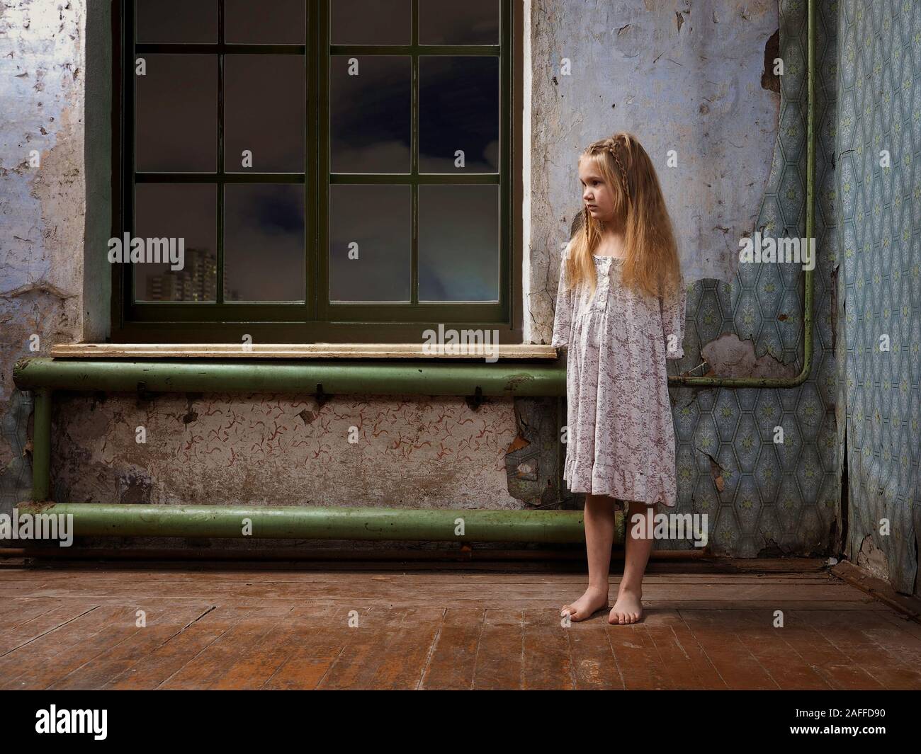 Una bambina in una vecchia casa abbandonata. Il concetto di figli  indesiderati, handicap Foto stock - Alamy