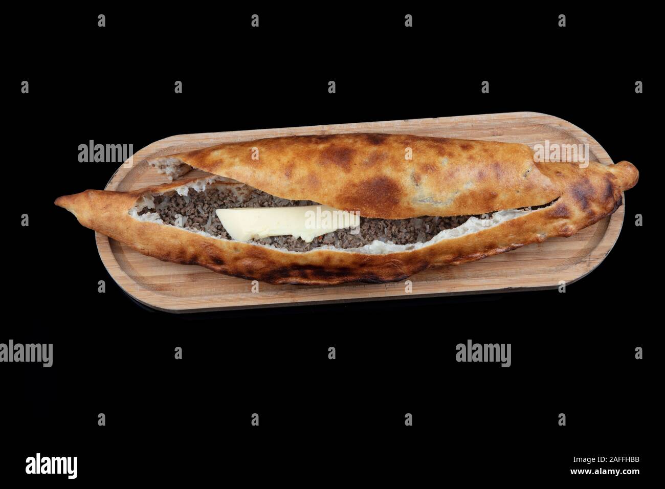 Bagno turco Karadeniz Pide con sminuzzato (Kiymali Pide). Bagno turco pita (Karadeniz Pidesi) concetto di pane su sfondo nero. Foto Stock