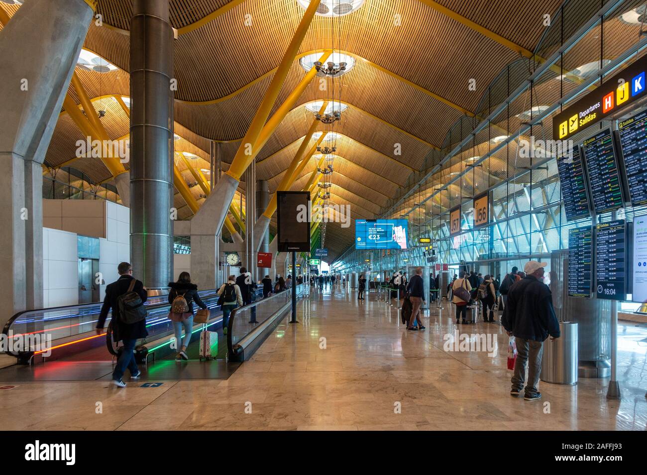 I passeggeri di fretta alla loro partenza i cancelli in Madrid-Barajas Adolfo Suárez Aeroporto, Madrid, Spagna. Architettura moderna con tenuta ondulato e parete in vetro Foto Stock