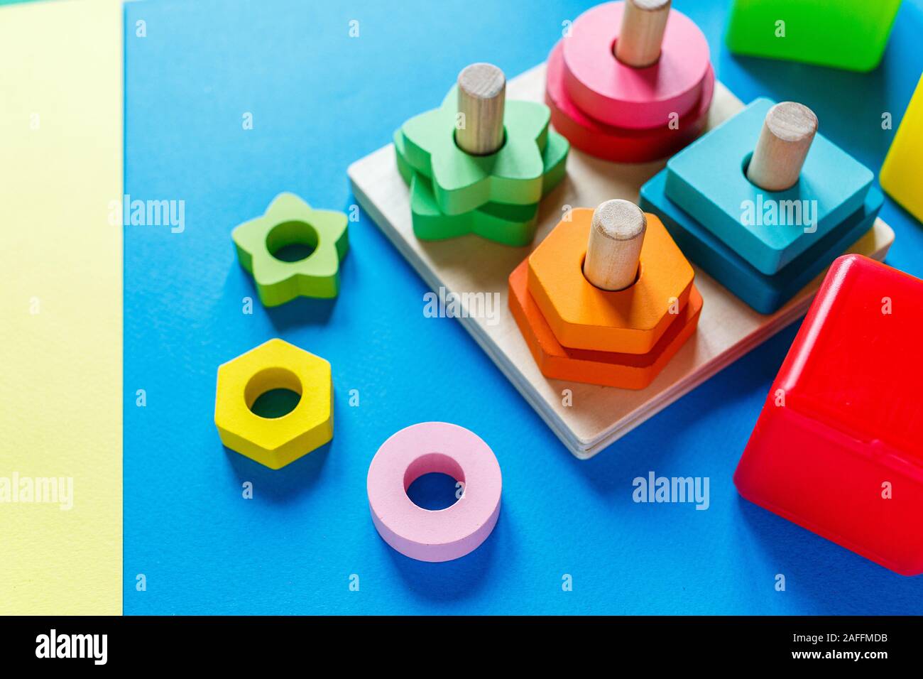Legno giocattoli per bambini su carta colorata. Giocattoli educativi blocchi, piramide. Giocattoli per asili, scuola materna o asilo nido. Copia spazio per il testo. Vista superiore Foto Stock