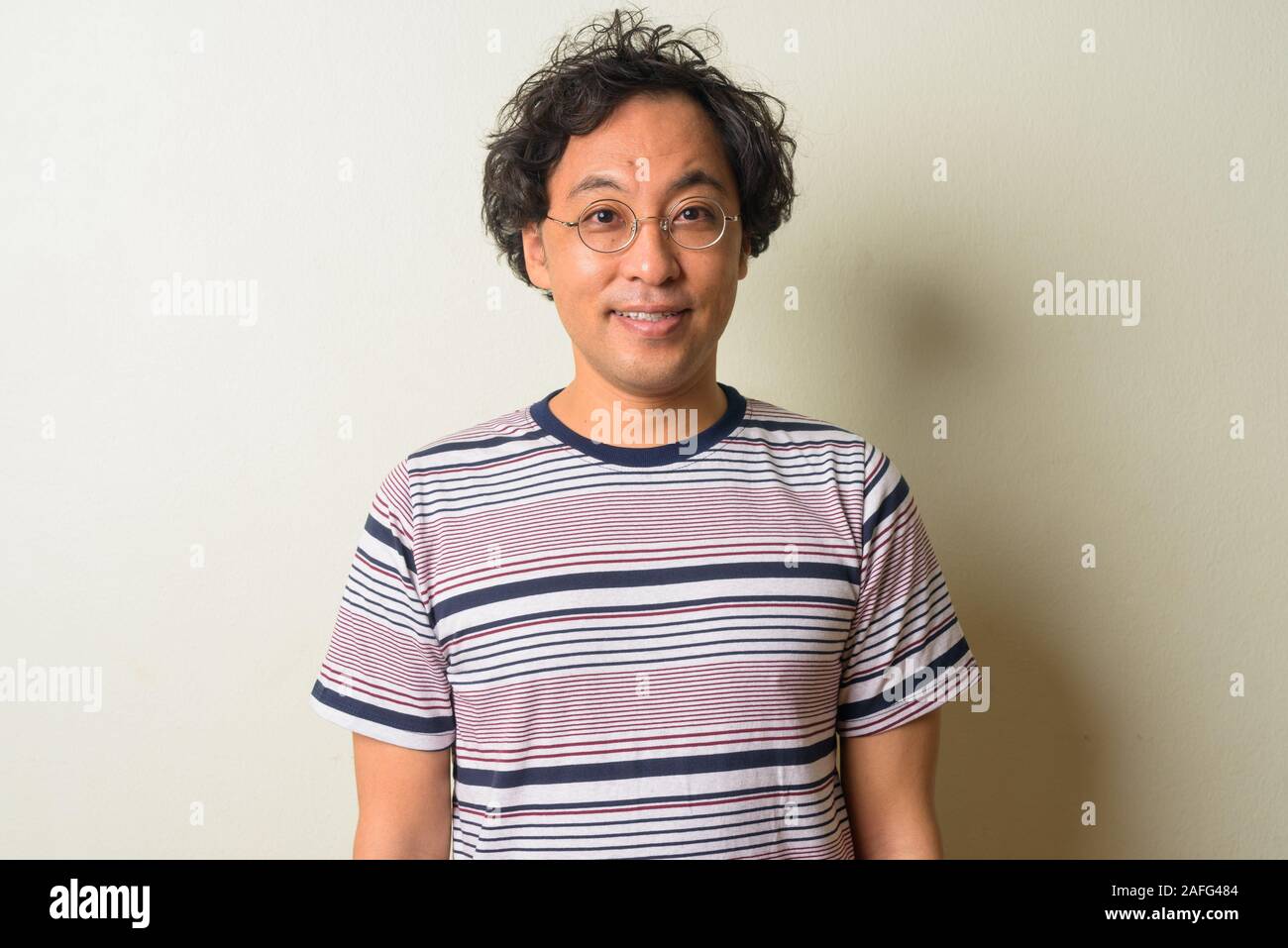 Faccia di felice uomo giapponese con capelli ricci sorridente Foto Stock