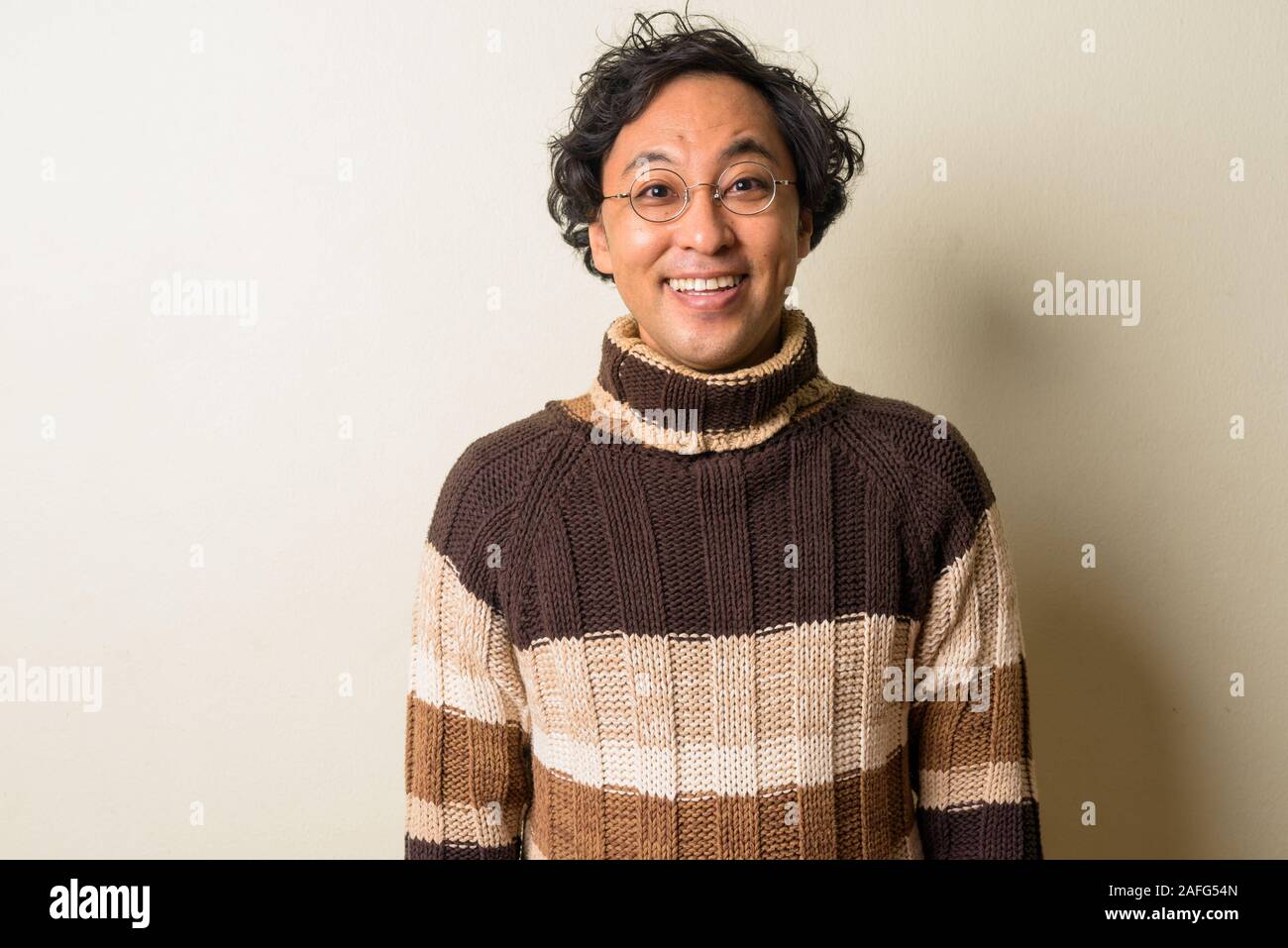 Faccia di felice uomo giapponese con occhiali sorridente pronto per l'inverno Foto Stock