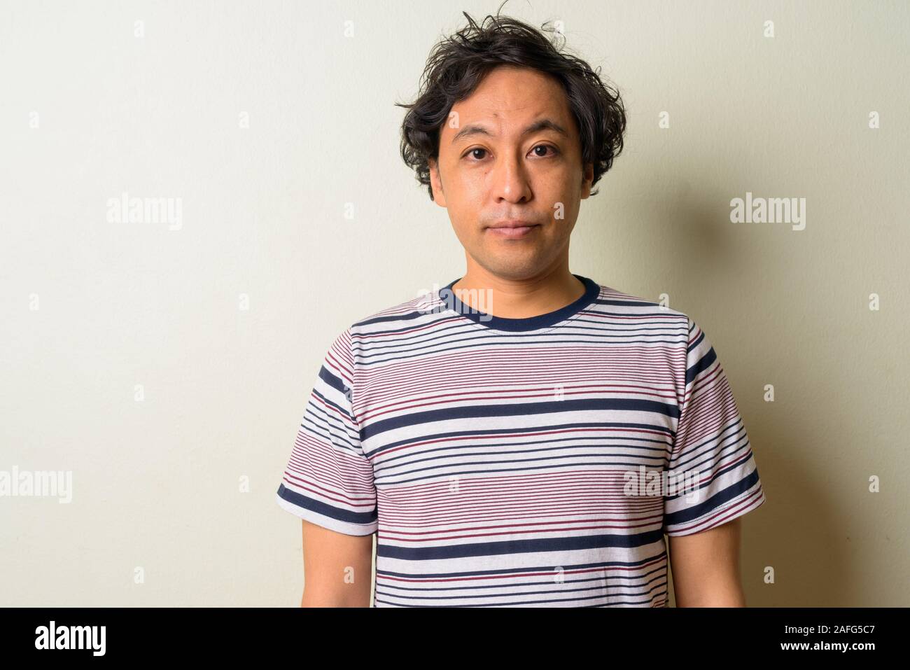 Volto di uomo giapponese con capelli ricci Foto Stock
