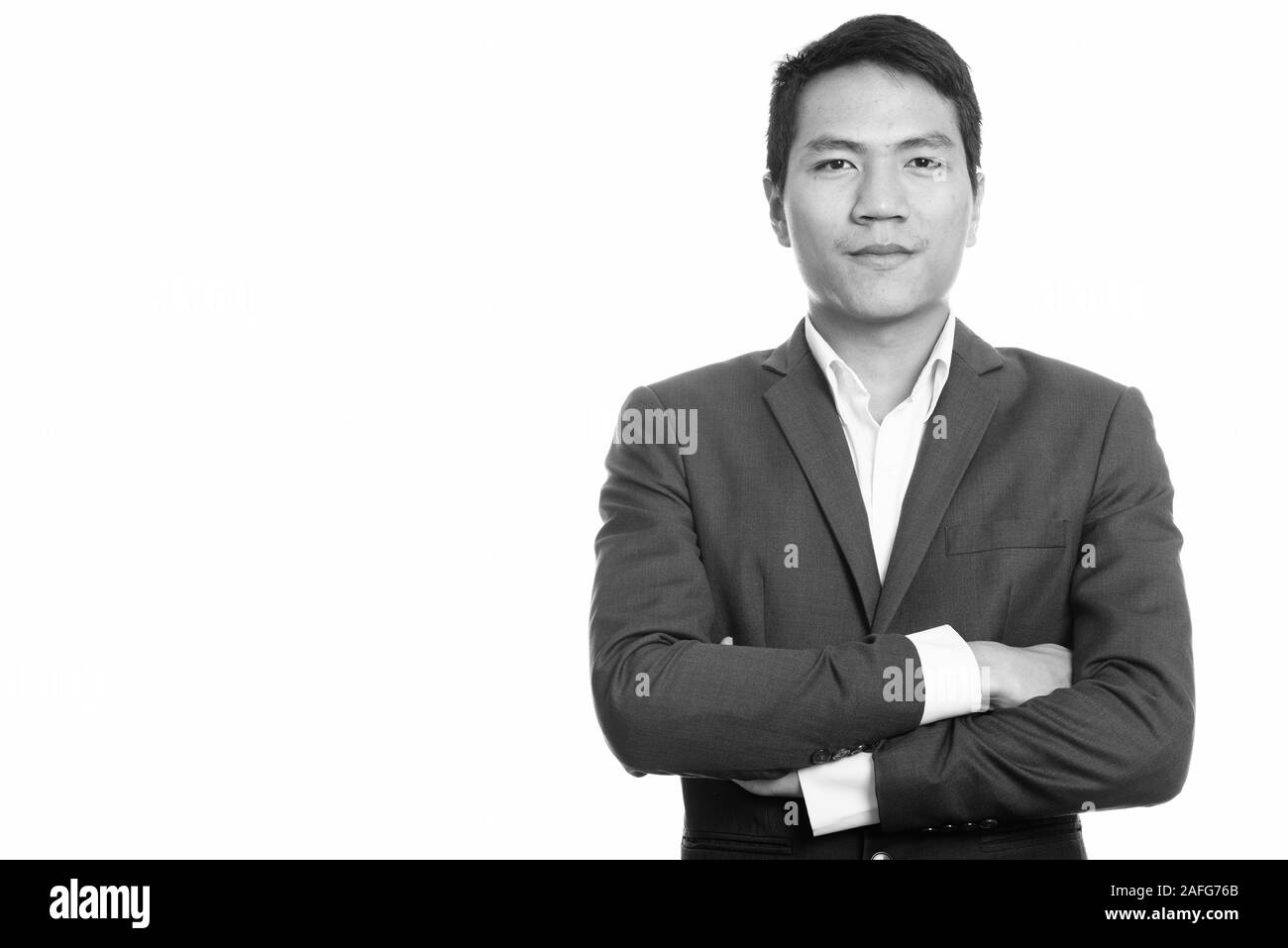 Studio shot del giovane imprenditore asiatico con le braccia incrociate Foto Stock