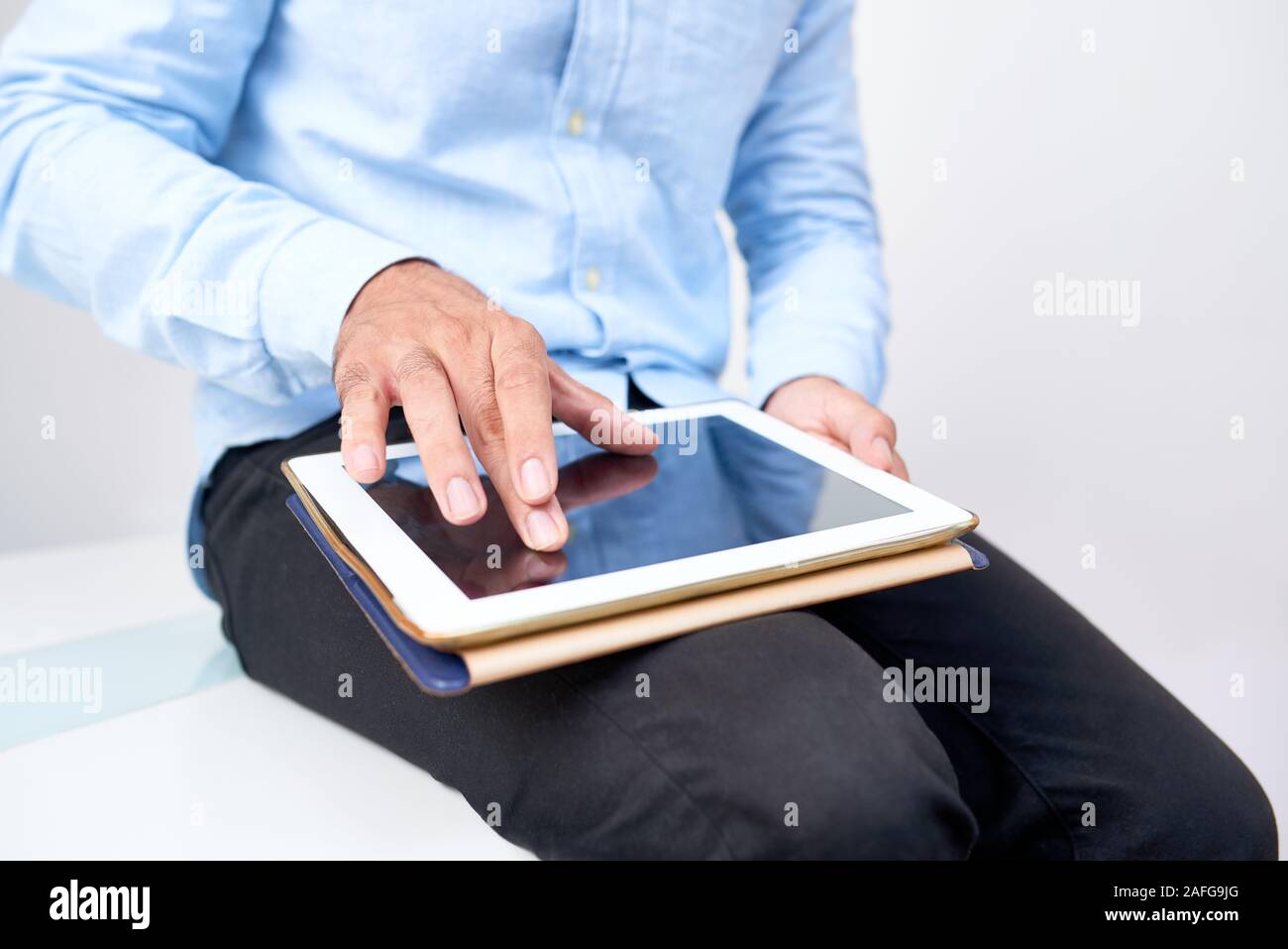 Imprenditore cercando alcune informazioni su internet e ingrandire le immagini sullo schermo del suo computer tablet Foto Stock