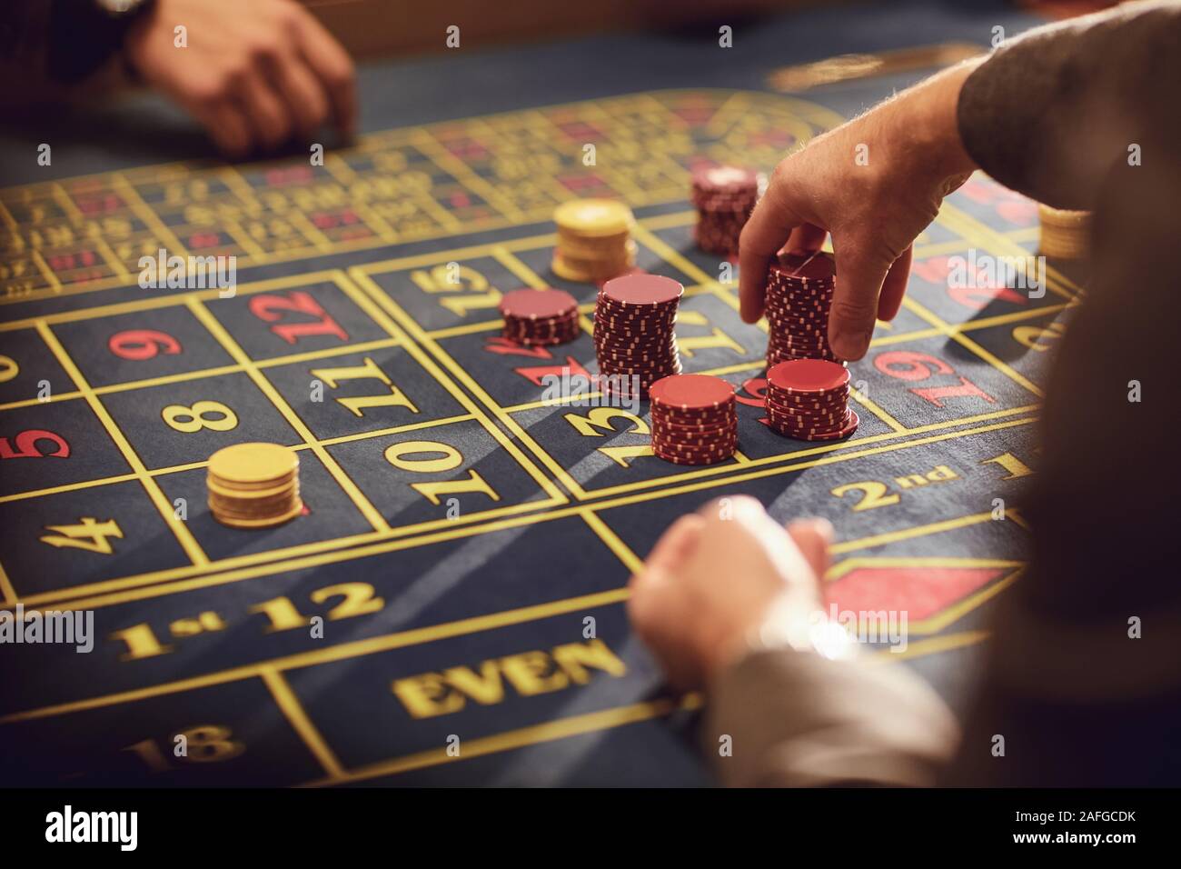 Una mano con i chips effettua una puntata alla roulette in un casinò. Foto Stock