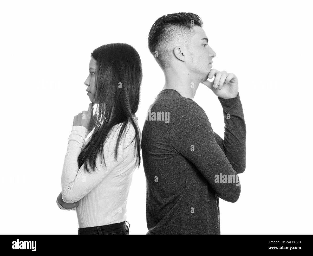 Vista di profilo di coppia giovane pensare insieme dorso a dorso Foto stock  - Alamy
