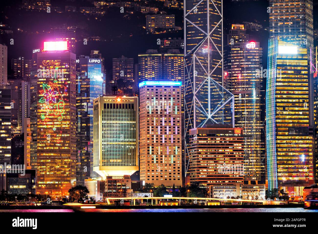 Centrale di edifici sul lungomare illuminato di notte. Hong Kong, Cina. Foto Stock