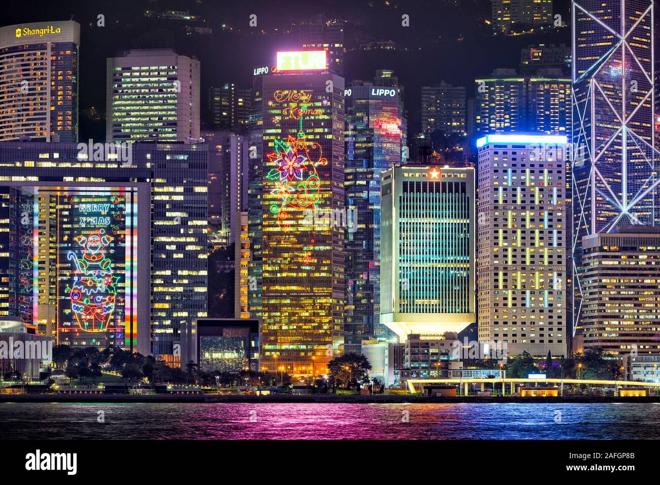 Centrale di edifici sul lungomare illuminato di notte. Hong Kong, Cina. Foto Stock